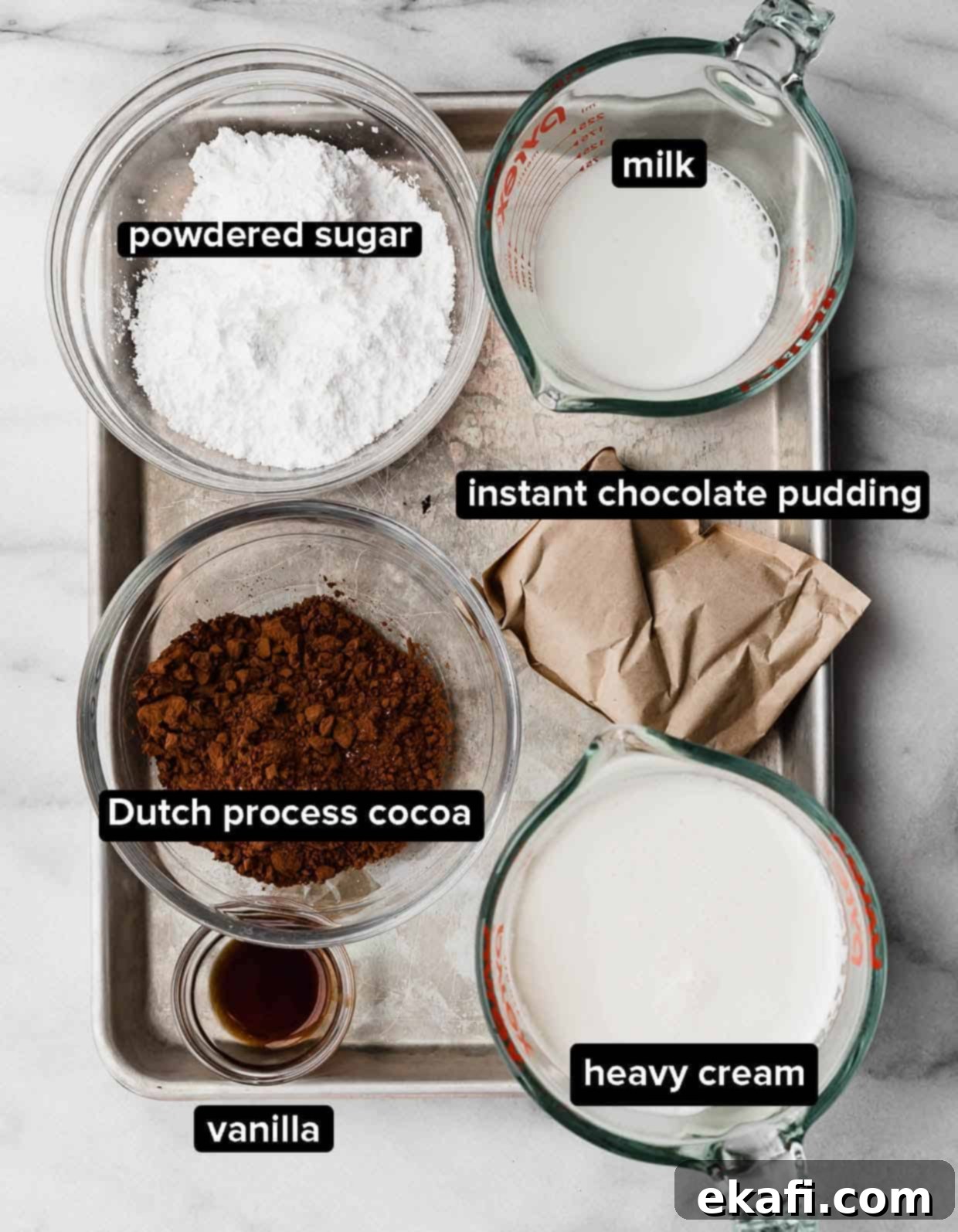 Oreo Mud Pie Cookies 4 Dirt Cake Cookie frosting ingredients on a white background: cocoa powder, milk and heavy cream, instant chocolate pudding, powdered sugar, and vanilla.