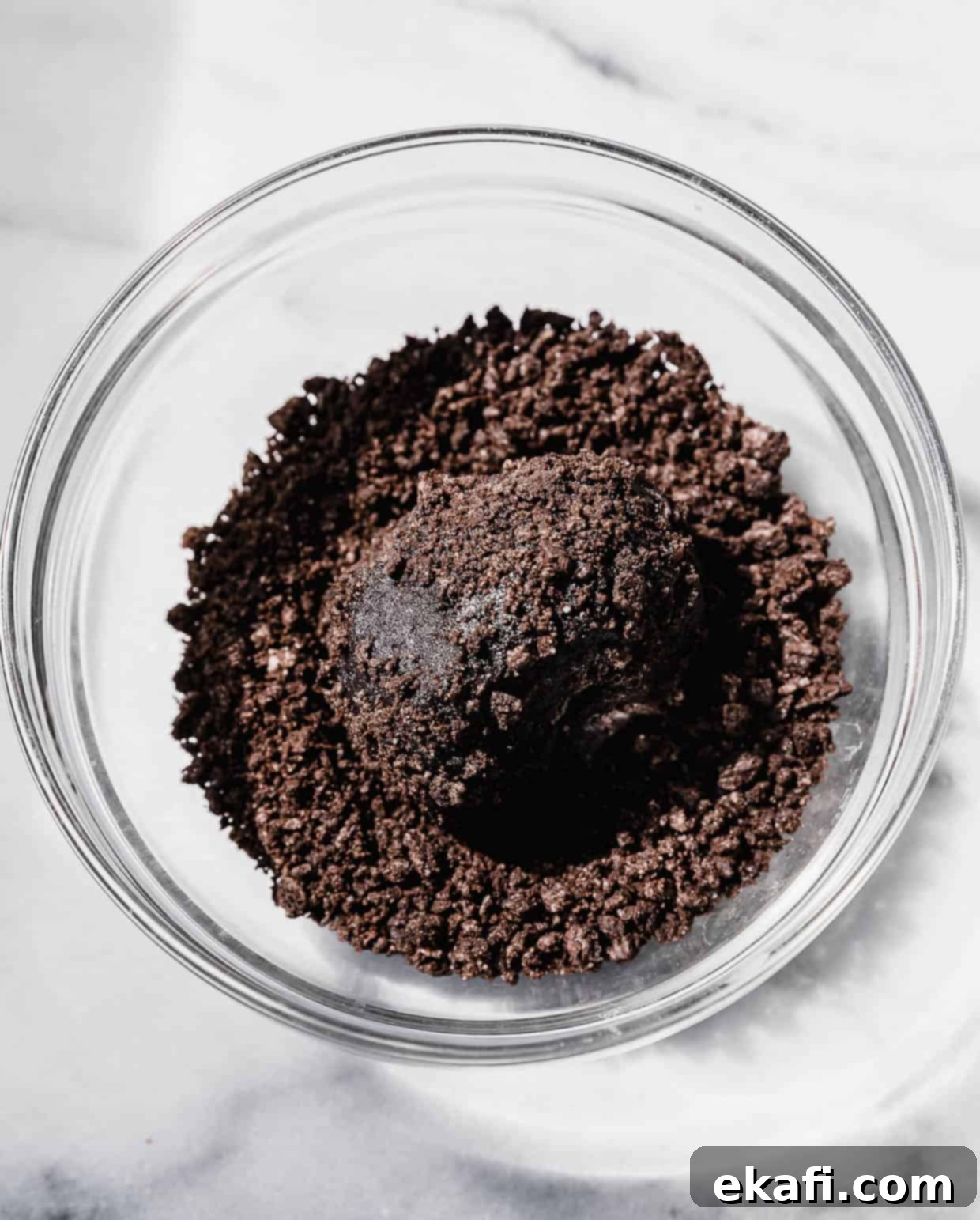 Oreo Mud Pie Cookies 6 A black Oreo based cookie dough rolled in a ball in a bowl filled with crushed Oreo crumbs.