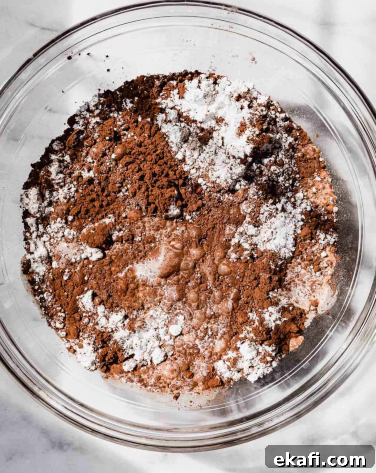 Oreo Mud Pie Cookies 9 Cocoa powder, powdered sugar, and milk in a glass bowl on a marble background.