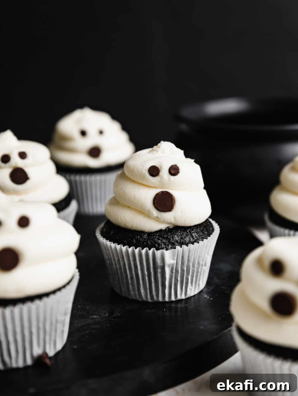 Phantom Frosted Treats 2 Ghost Cupcakes on a black table against a black background.