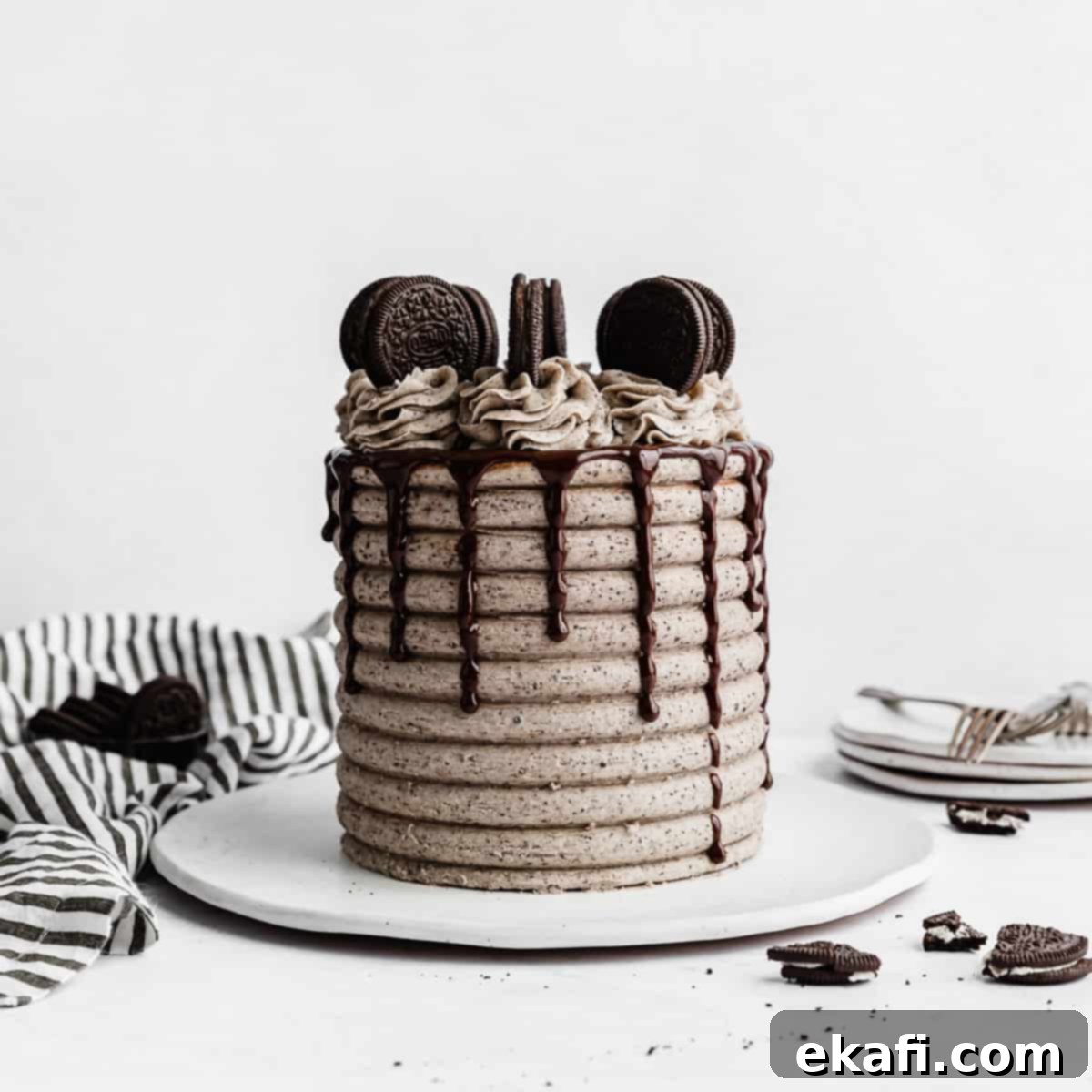 Petite Cake Perfection 3 A Coconut Cookies and Cream Cake on a white plate against a white background.