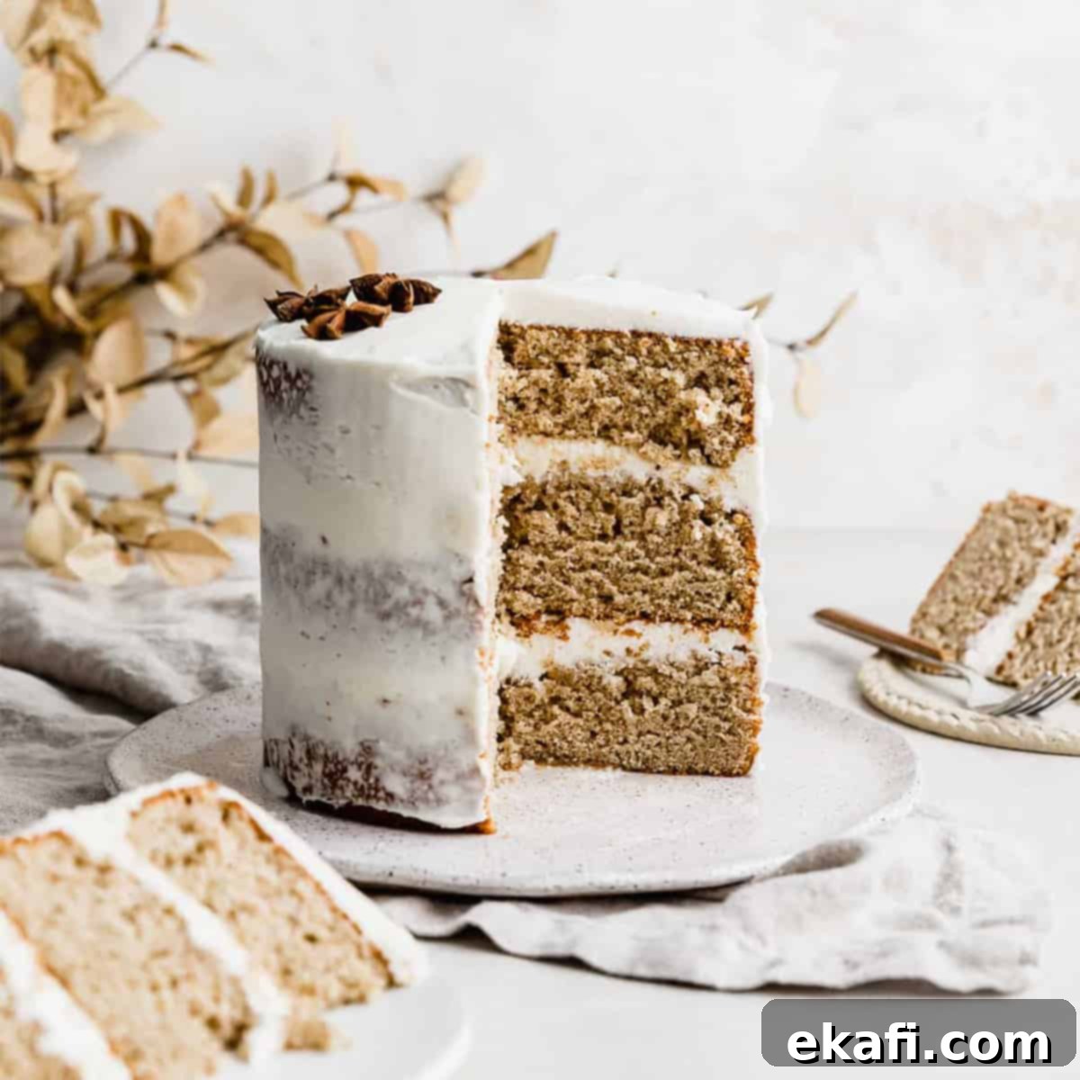 Petite Cake Perfection 5 A beautifully frosted spice cake with cream cheese frosting, garnished with a sprinkle of cinnamon.