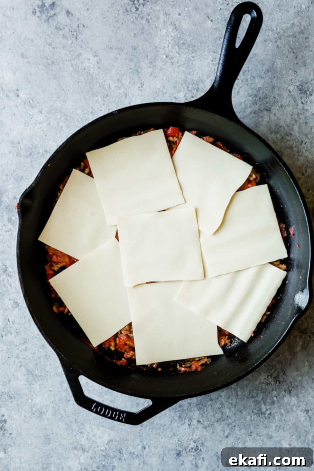 Rustic Cast Iron Lasagna 6 8 squares of no boil noodles spread along the bottom of a black skillet.