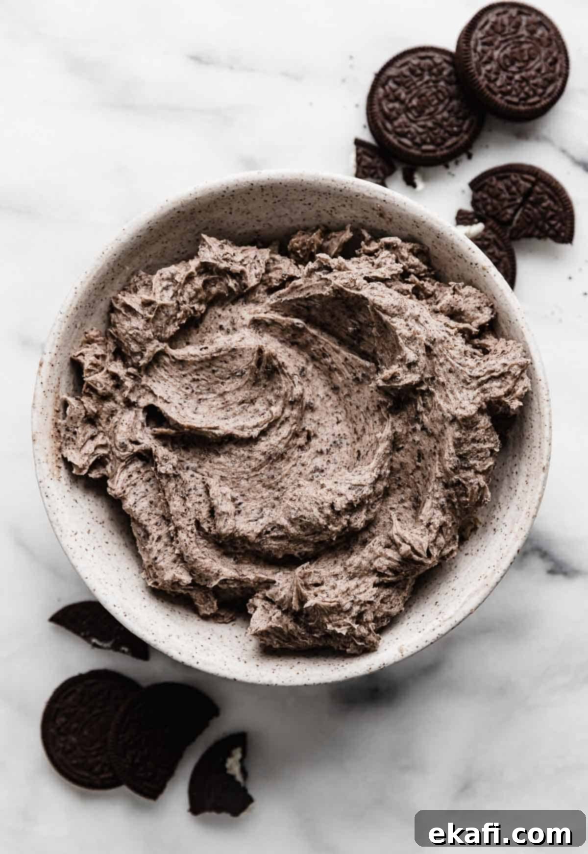 Oreo Γλάσο 6 Ένα λευκό μπολ γεμάτο με βουτυρόκρεμα Oreo (κρέμα μπισκότο και κρέμα) σε μαρμάρινο φόντο.