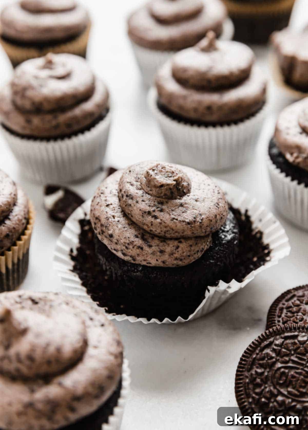Oreo Καπκέικς 2 Oreo Cupcakes σε λευκό φόντο, με κάθε cupcake να έχει μια σπείρα γλάσο Oreo στην κορυφή.