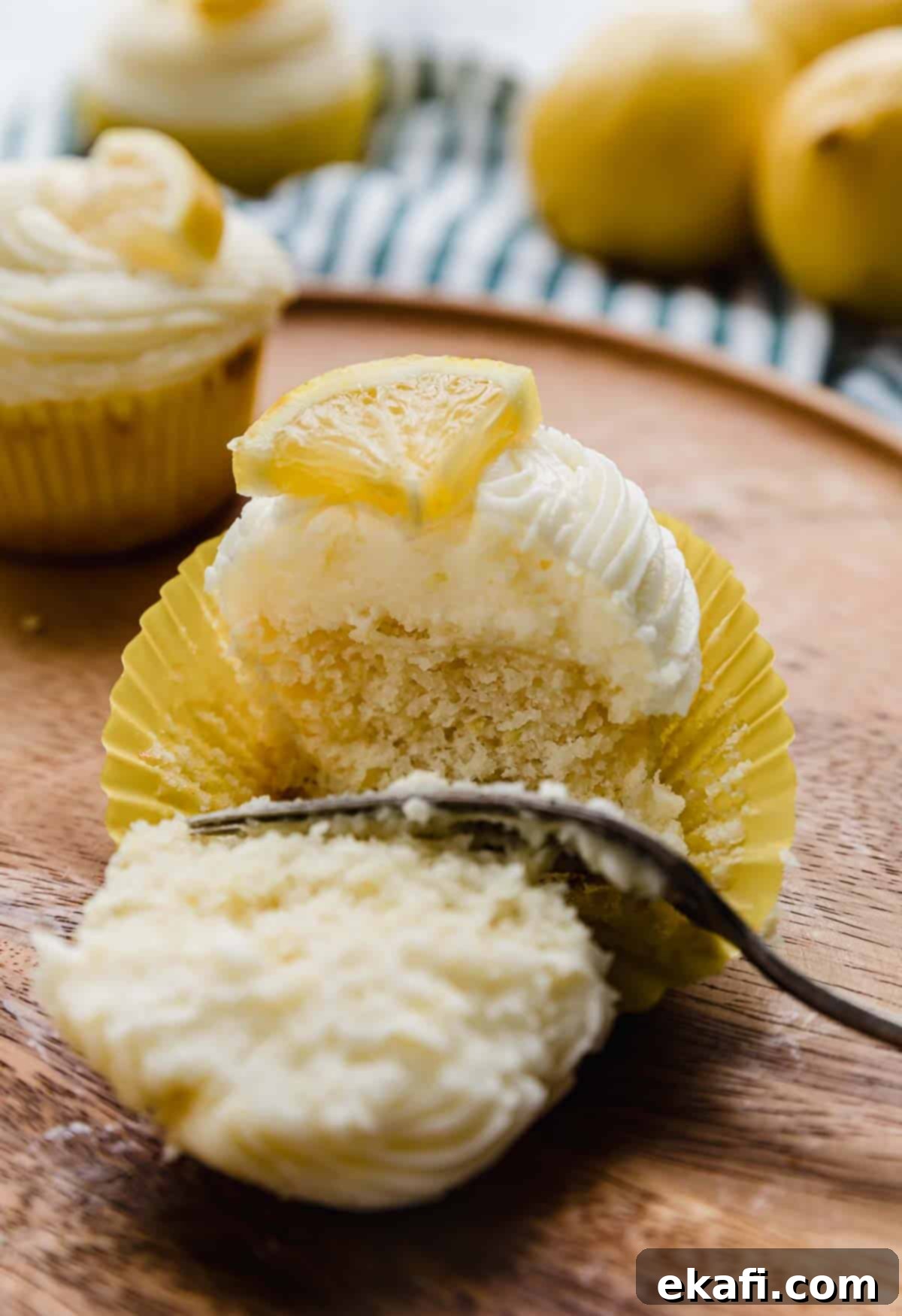 Zesty Lemon Cupcakes 7 A fork cutting a lemon cupcake in half.