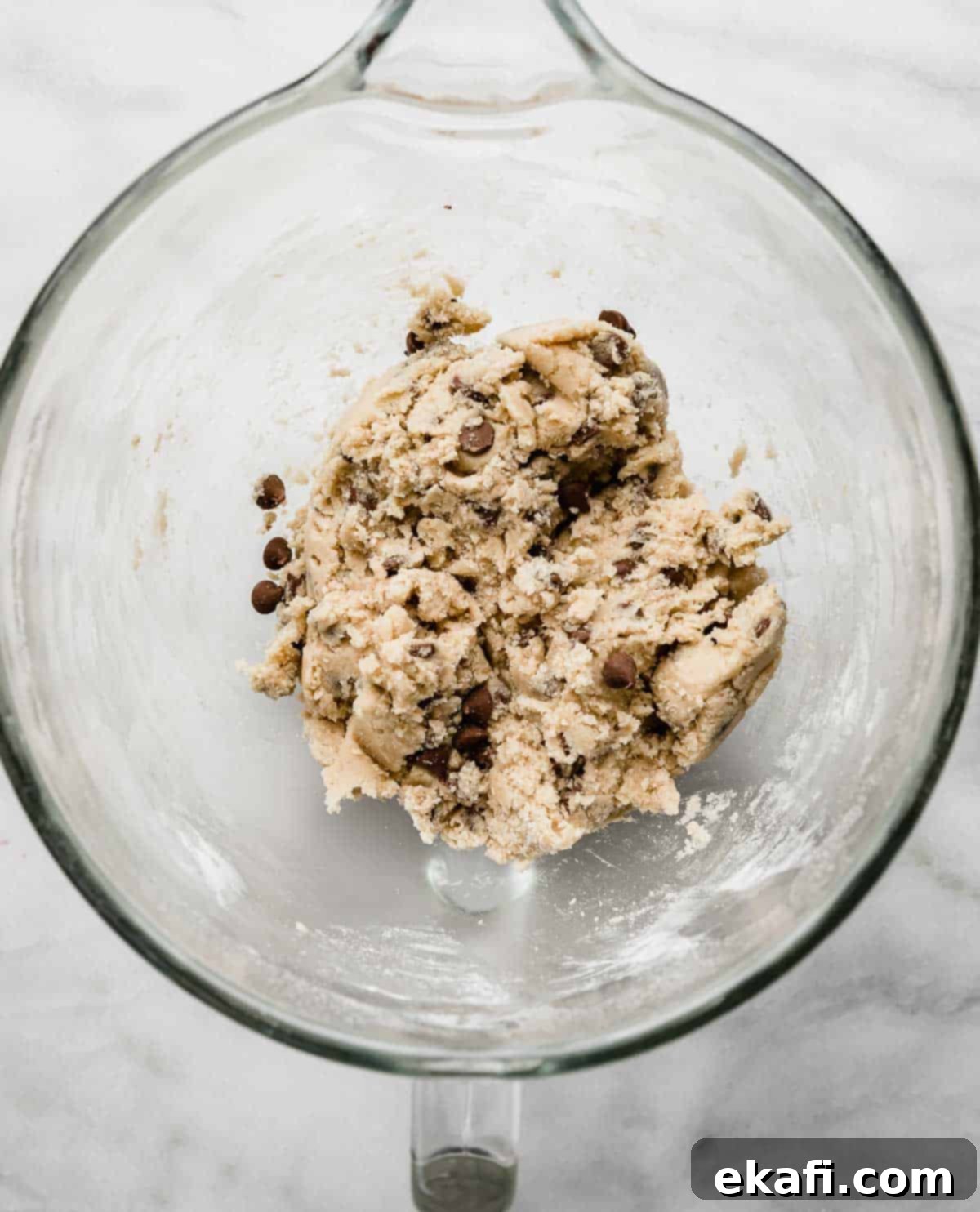 Irresistible Milk Chocolate Chip Cookies 4 Milk Chocolate Chip Cookie dough ready in a glass stand mixer bowl on a clean white background.