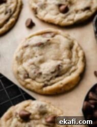 Irresistible Milk Chocolate Chip Cookies 9 A perfectly baked milk chocolate chip cookie resting on a black wire cooling rack, showcasing its golden edges and soft center.