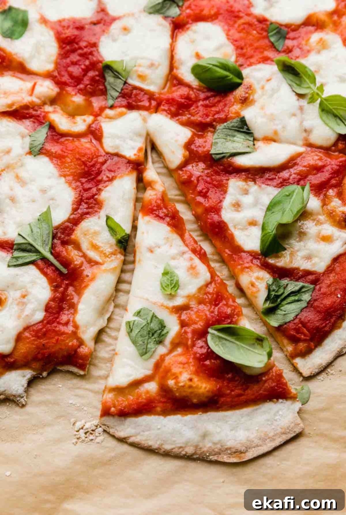 The Original Margherita Pizza 4 A slice of margherita pizza on a Kraft parchment paper.