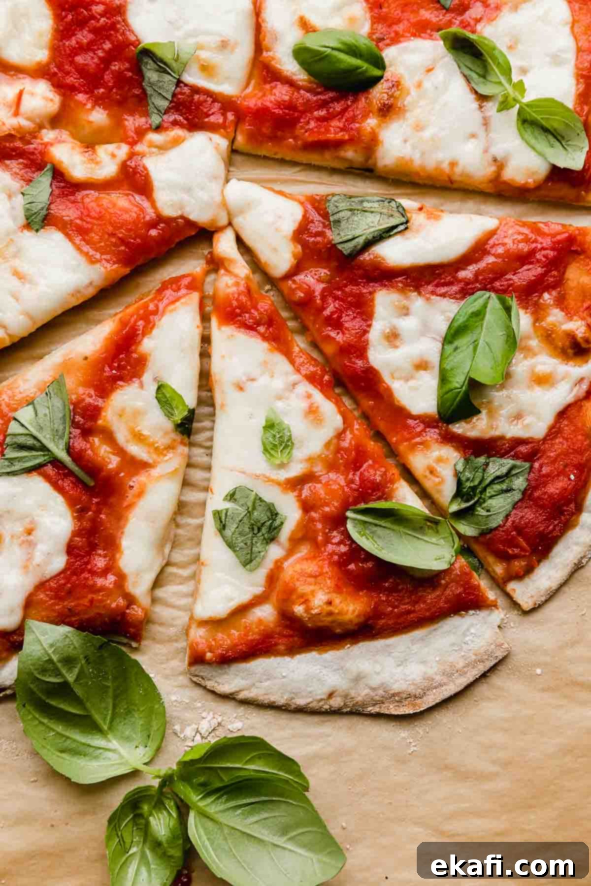 The Original Margherita Pizza 5 Several slices of Margherita Pizza with crushed tomatoes and fresh basil.