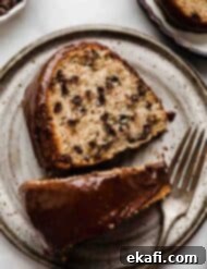 Rich Chocolate Chip Bundt Perfection 7 A slice of moist Chocolate Chip Bundt Cake with chocolate glaze on a gray plate.