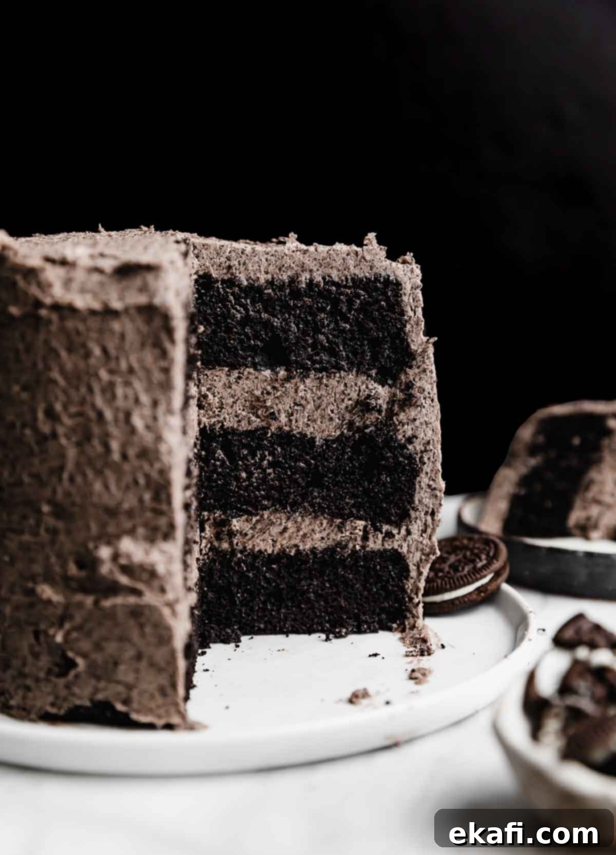 Decadent Oreo Dream 2 A three layer six inch Oreo Cake recipe topped with an Oreo frosting, against a black background.