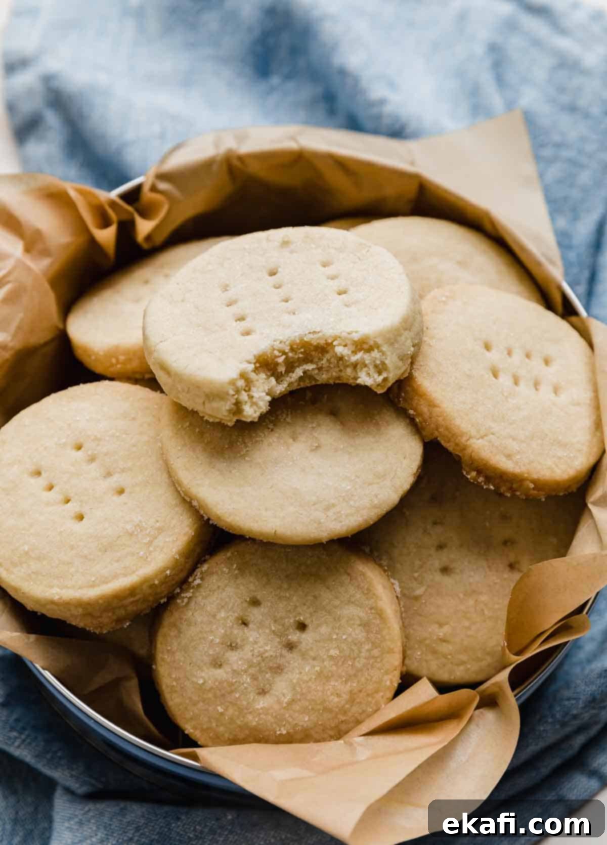 Grandma's Buttery Shortbread 2 A round shortbread cookie with sugar on top, in a round tin with a bite taken out of the cookie.