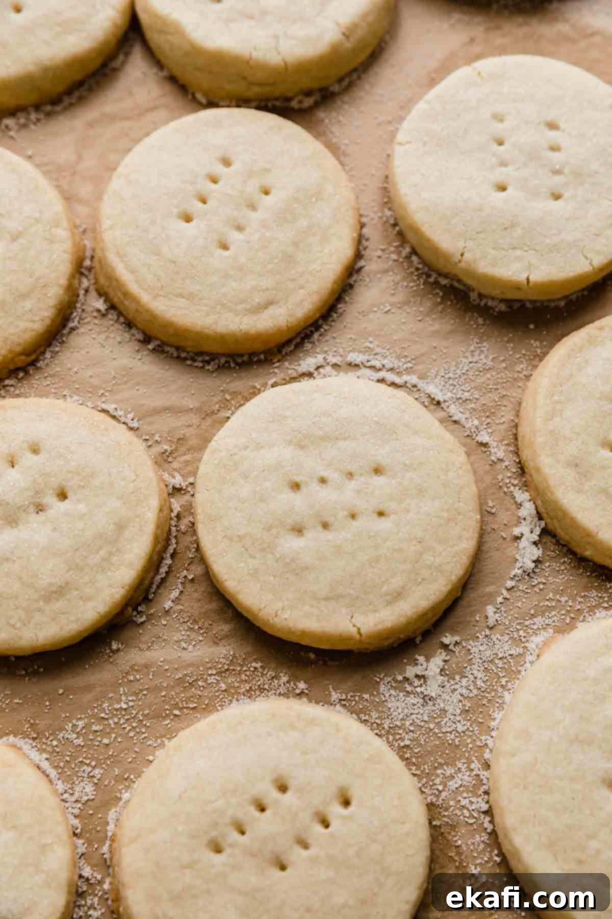 Grandma's Buttery Shortbread 7 Round shortbread cookies on a tan colored parchment paper.
