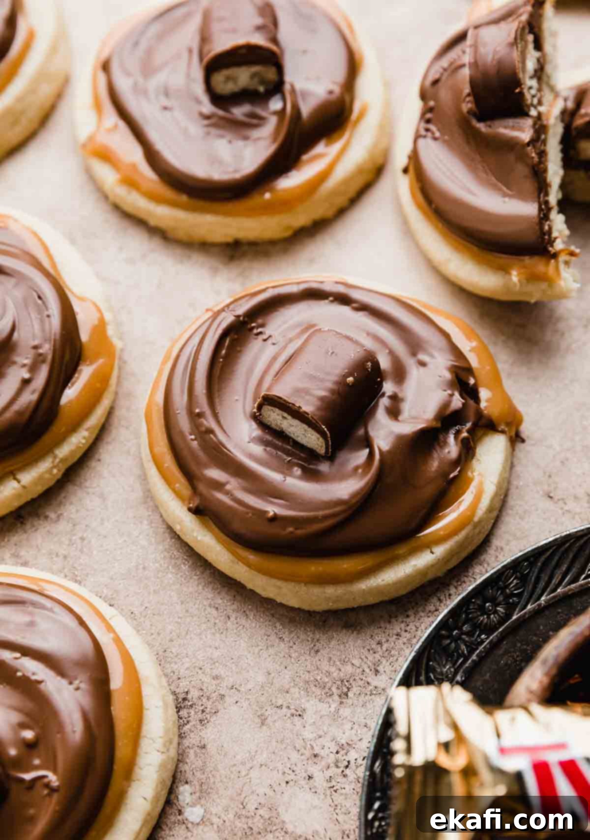 Τουίξ Μπισκότα 6 Μπισκότα Twix σε ανοιχτό καφέ φόντο, με κάθε μπισκότο επικαλυμμένο με μια μίνι μπάρα Twix.