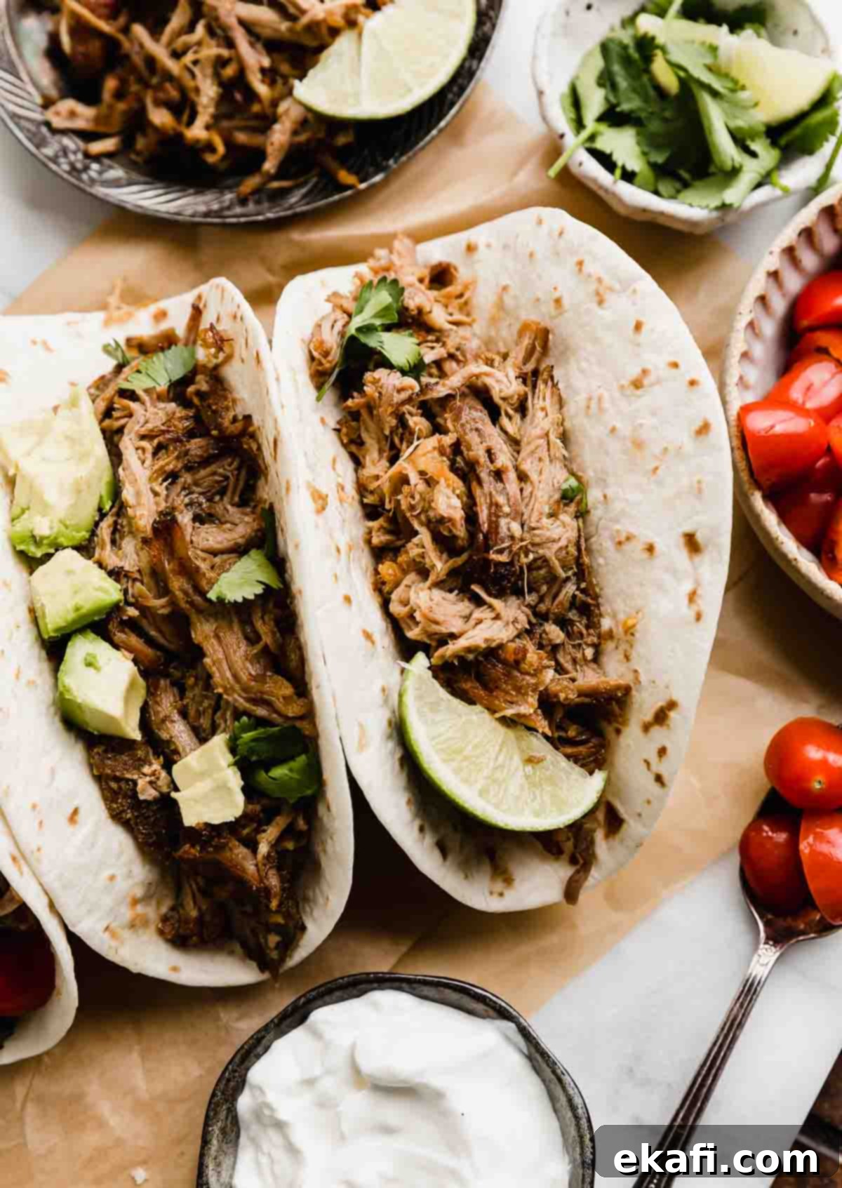 Carnitas 2 Two flour tortillas filled with slow cooker Mexican pulled pork carnitas, topped with chopped avocado and a side of tomatoes.