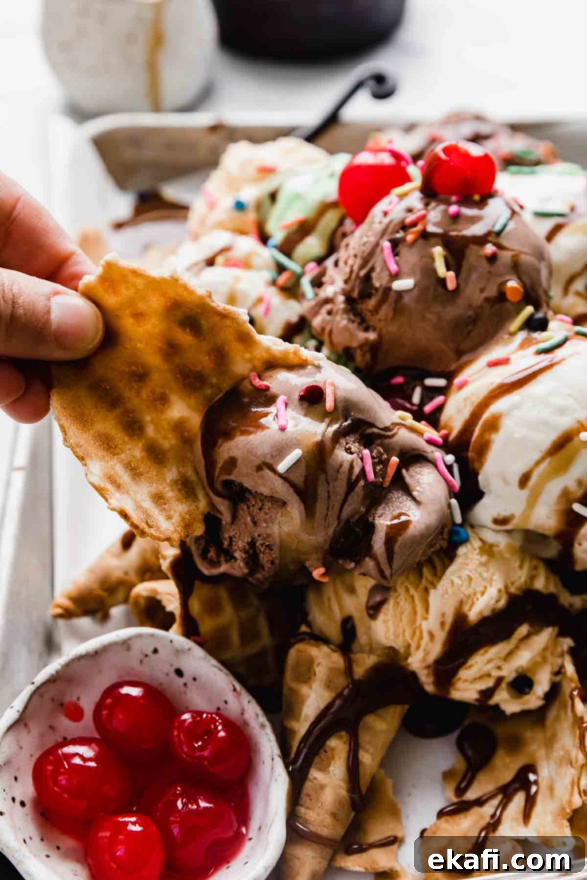 The Sweet Scoop Fiesta 7 A waffle cone piece being used to scoop of chocolate ice cream.