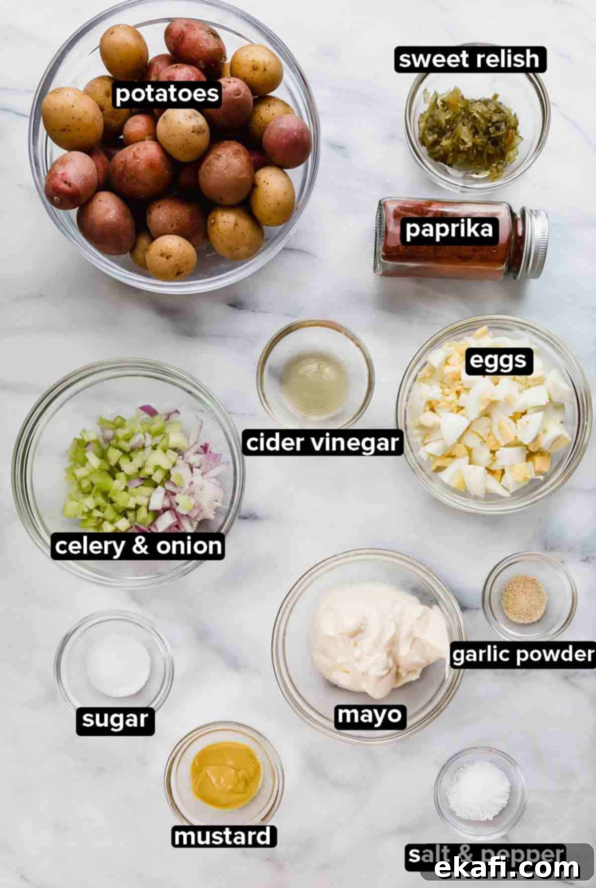 Homestyle Baby Potato Salad 3 Baby Potato Salad ingredients in glass bowls: baby potatos, paprika, sweet relish, boiled eggs, sugar, mustard, mayo on a white background.