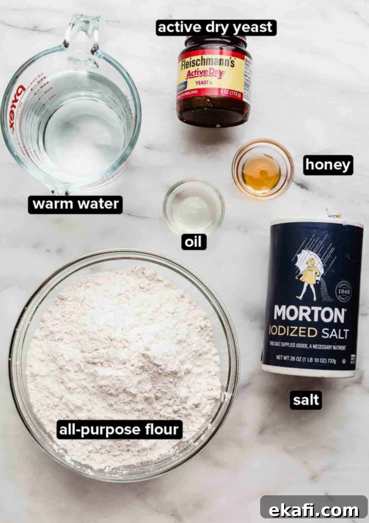 Flawless Pizza Dough Every Time 3 Pizza Dough Recipe ingredients on a white background: warm water, all-purpose flour, active dry yeast, honey, and salt.