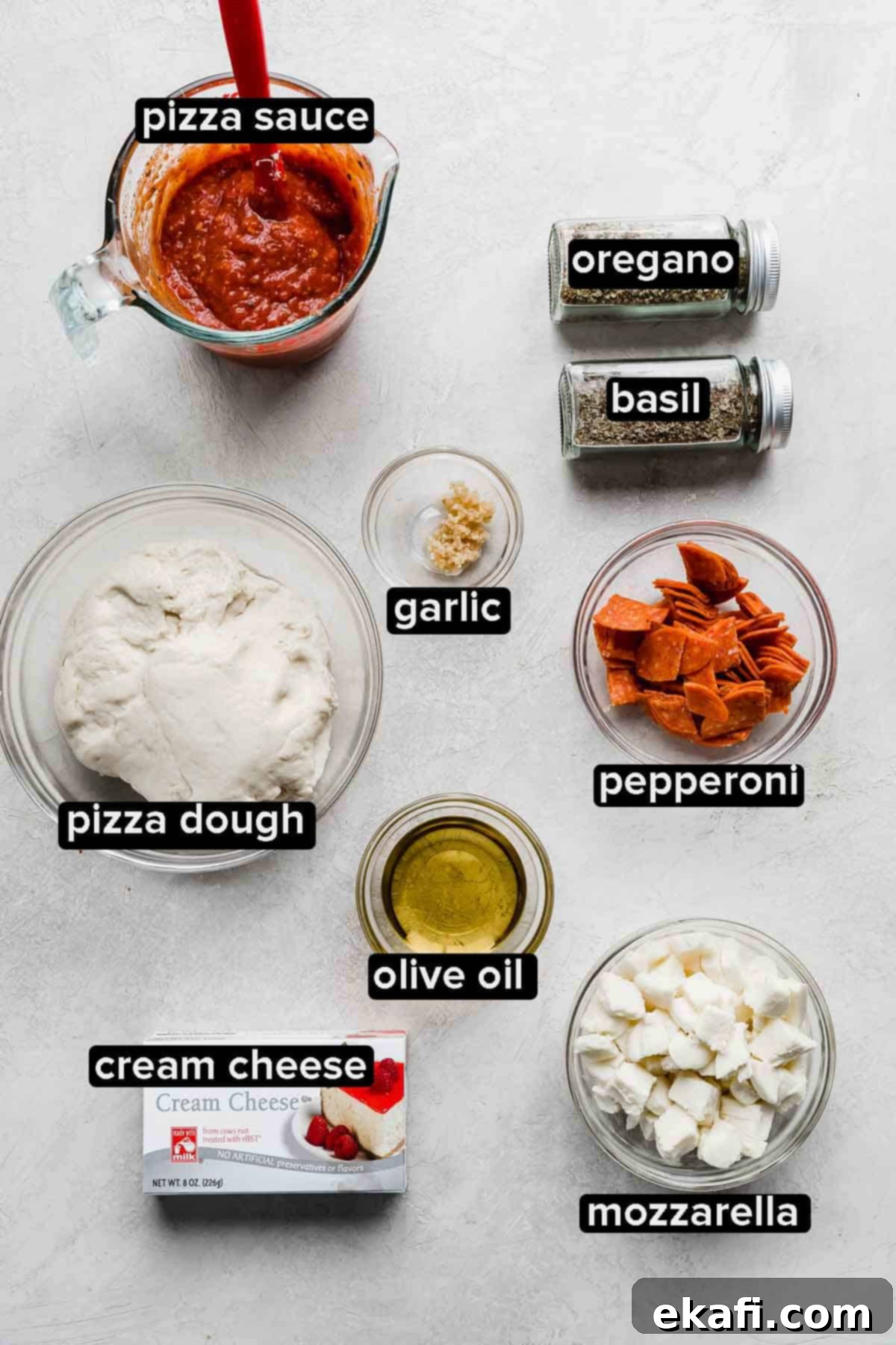 Ultimate Pepperoni Pizza Dip 2 Pepperoni Pizza Dip ingredients meticulously laid out on a clean white background, including fresh pizza dough, various cheeses, pepperoni, pizza sauce, olive oil, and herbs.