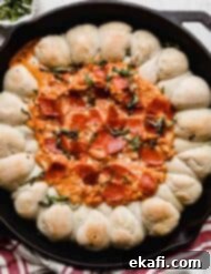 Ultimate Pepperoni Pizza Dip 8 A Pepperoni Pizza Dip in a skillet with pull-apart bread, garnished with fresh basil, ready for serving.