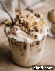 Δίνη Μπισκοτοζύμης Σοκολάτας 7 Chocolate Chip Cookie Dough Blizzard σε γυάλινο ποτήρι σε ανοιχτό καφέ ανάγλυφο φόντο.