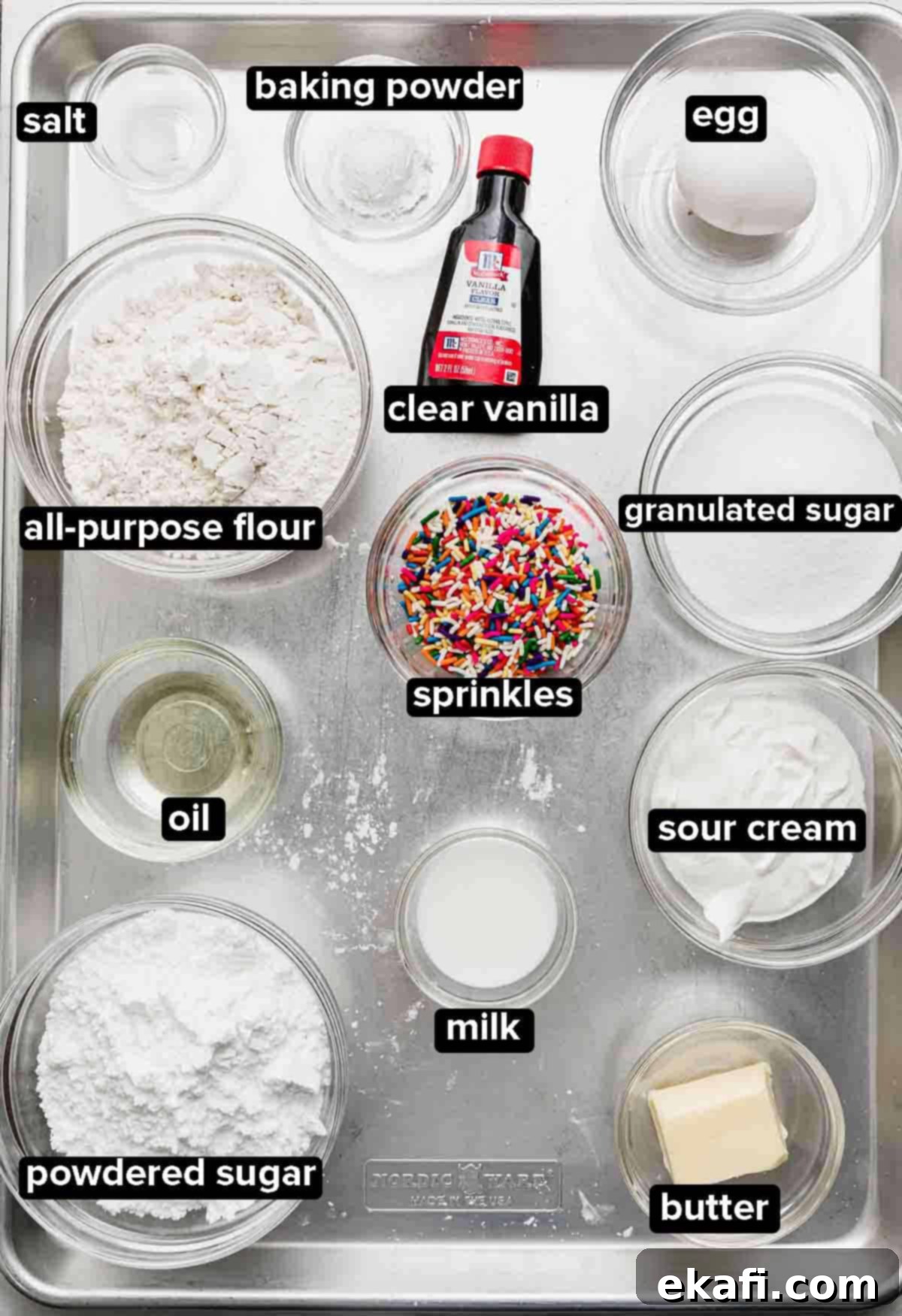 Confetti Delights 3 Sprinkle Donuts (funfetti donuts) ingredients portioned into glass bowls on a silver baking sheet.