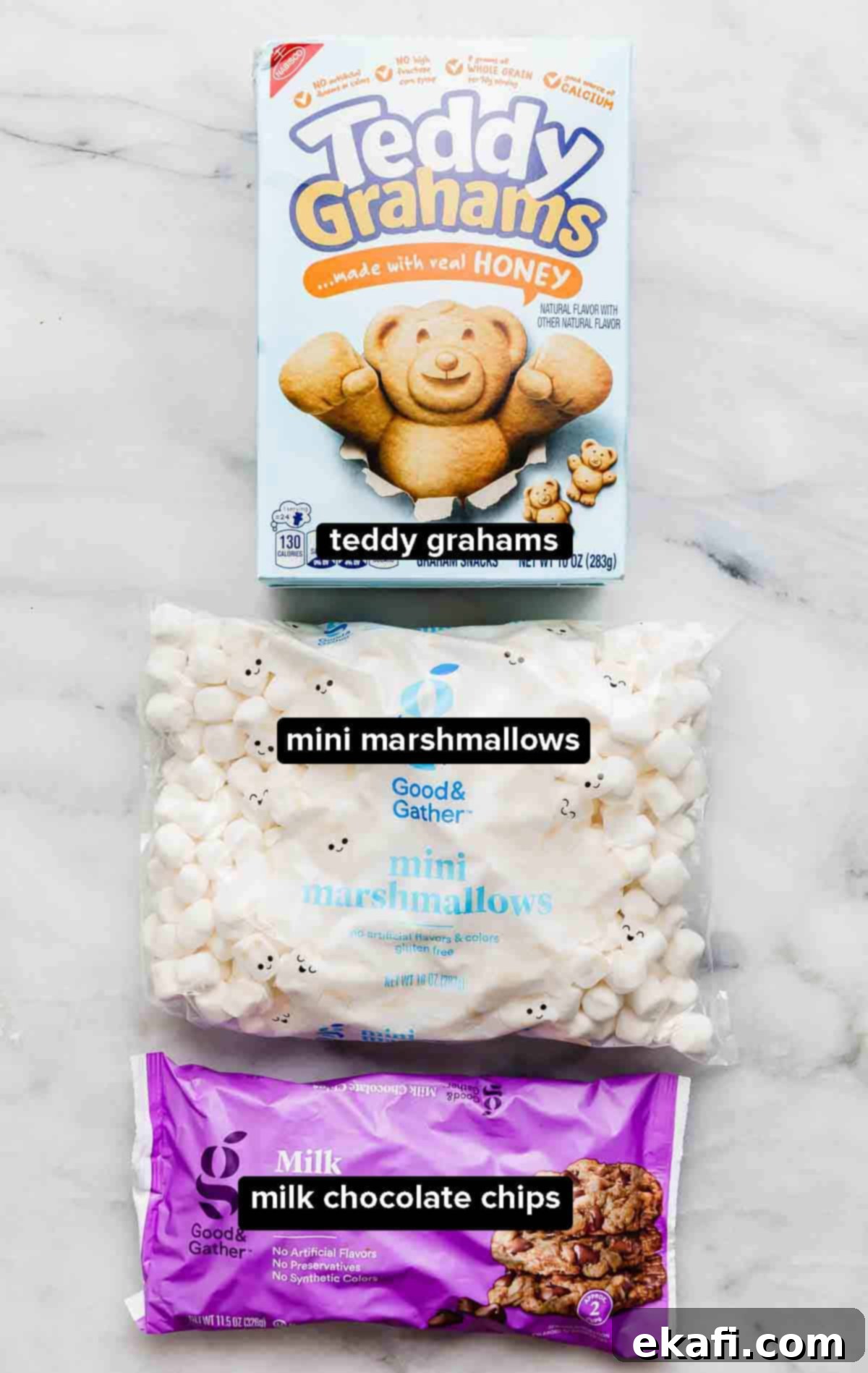 S'mores Mix 3 S'mores snack Mix ingredients: a box of teddy grahams, mini marshmallows, and a bag of milk chocolate chips on a white background.