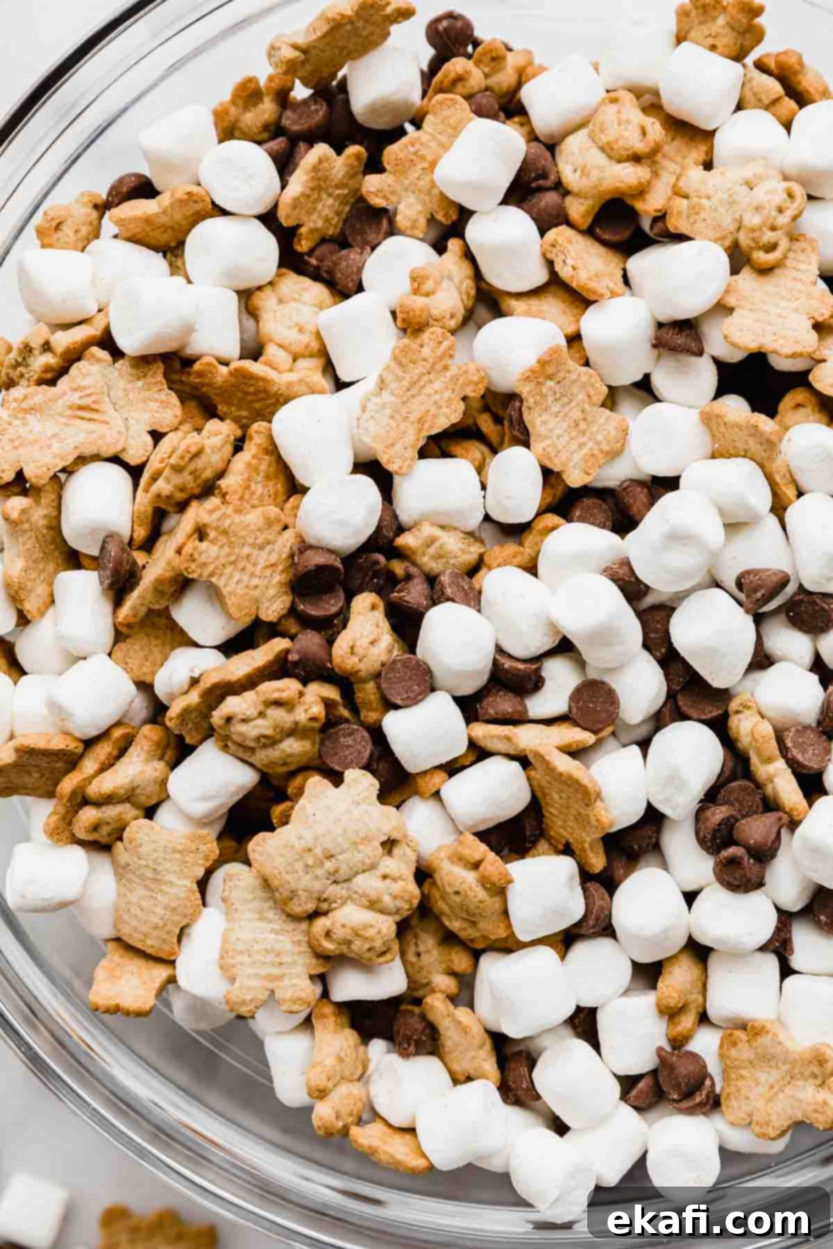 S'mores Mix 5 A close up of a S'mores Mix in a glass bowl (milk chocolate chips, marshmallows, and teddy grahams).
