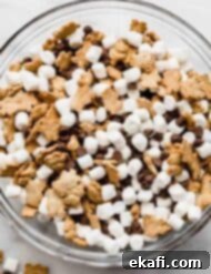 S'mores Mix 7 A large glass bowl filled with S'mores Mix: mini marshmallows, chocolate chips, and teddy grahams.