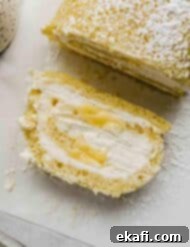 Ρολό λεμονιού 9 Μια φέτα Lemon Swiss Roll σε λευκό χαρτί ψησίματος.