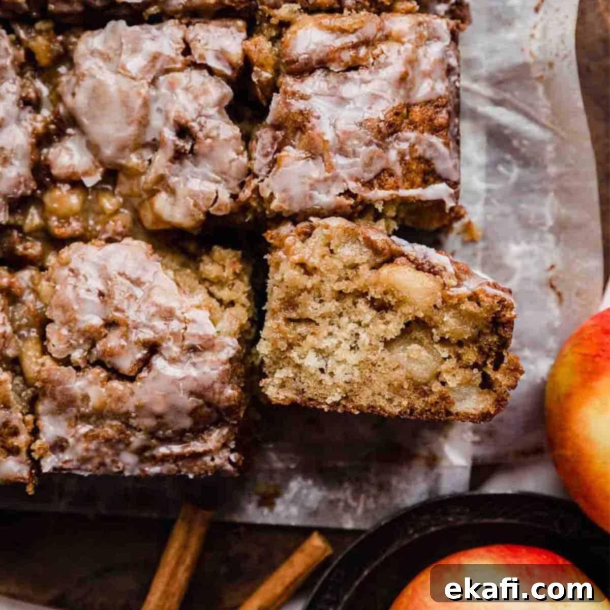 Baked Apple Fritter Delight 8 Close up photo of the best Apple Fritter Cake on parchment paper, showing the detailed texture of the cake and glaze.