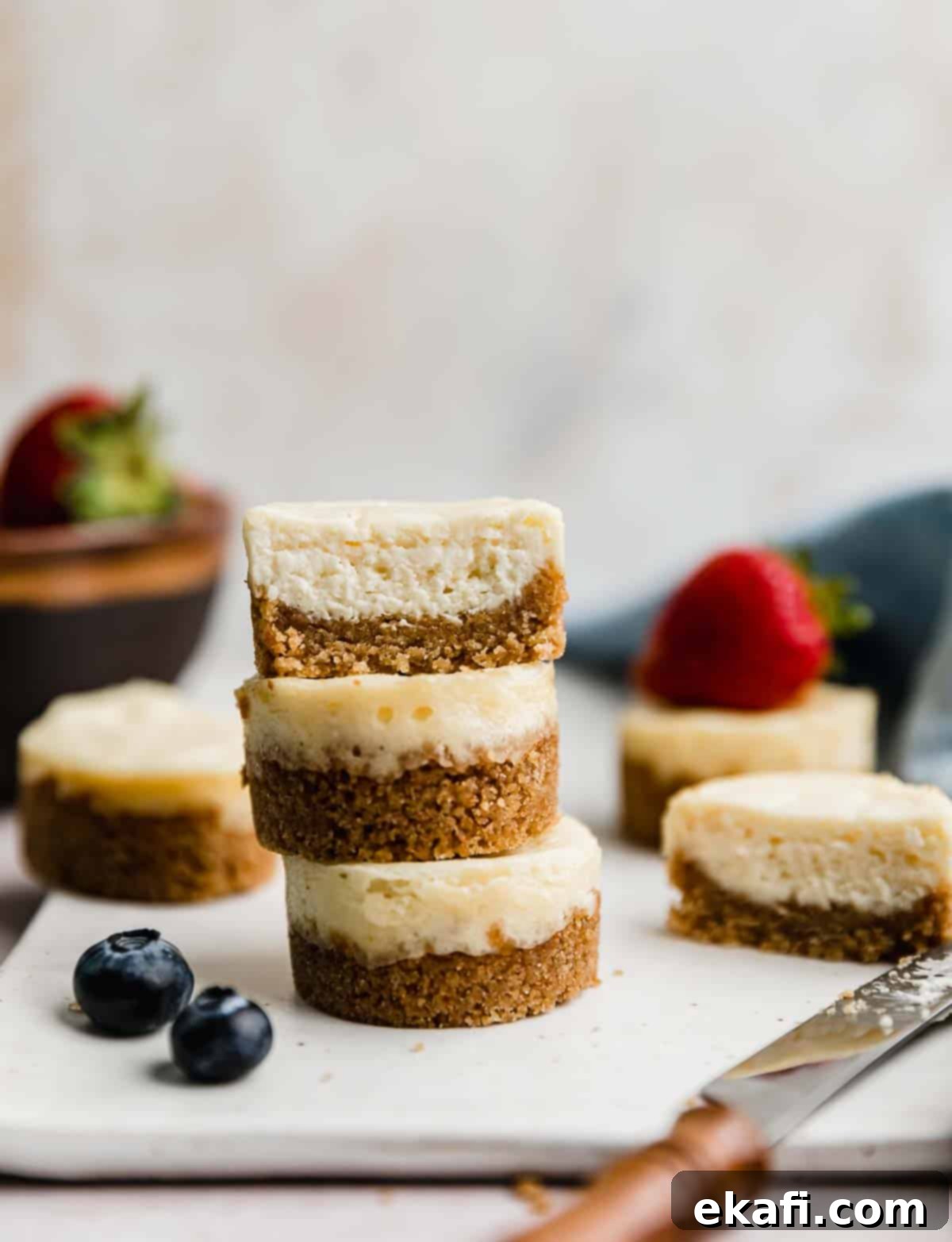 Bite-Sized Cheesecakes 2 Three Mini Cheesecakes stacked on top of each other against a light cream background.