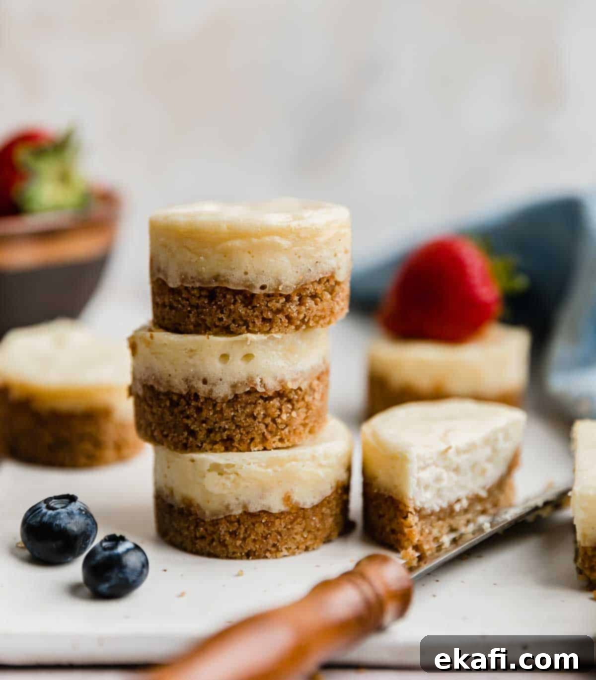 Bite-Sized Cheesecakes 7 A stack of three baked mini cheesecakes against a white background.
