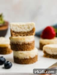 Bite-Sized Cheesecakes 9 A mini cheesecake cut in half, and stacked on two additional small cheesecakes on a white plate.