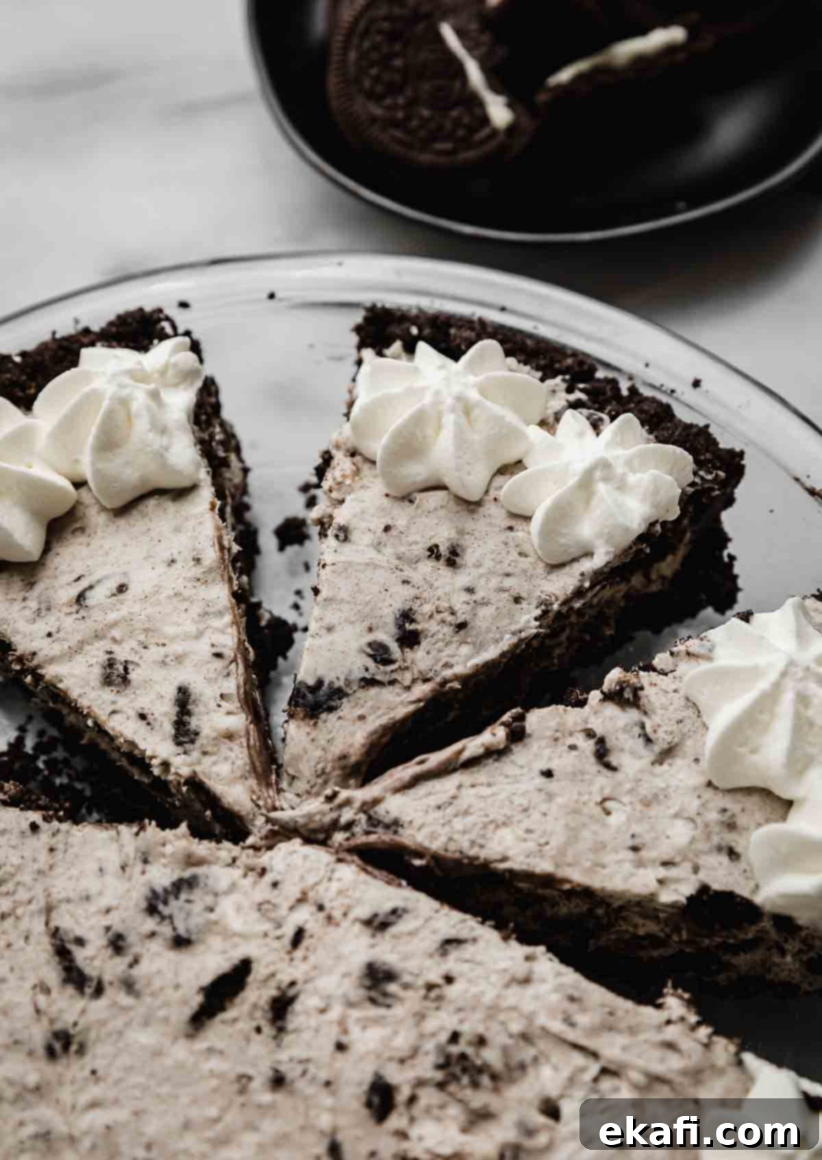Μπισκότα και Κρέμα Τάρτα 2 Cookies and Cream Pie κομμένη σε τριγωνικές φέτες και γαρνιρισμένη με σαντιγί.