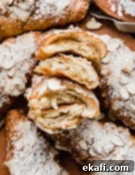 Αμυγδαλωτά Κρουασάν 9 Αφράτα σπιτικά Αμυγδαλωτά Κρουασάν κομμένα στη μέση και περιτριγυρισμένα από αμυγδαλωτά κρουασάν πασπαλισμένα με ζάχαρη άχνη.