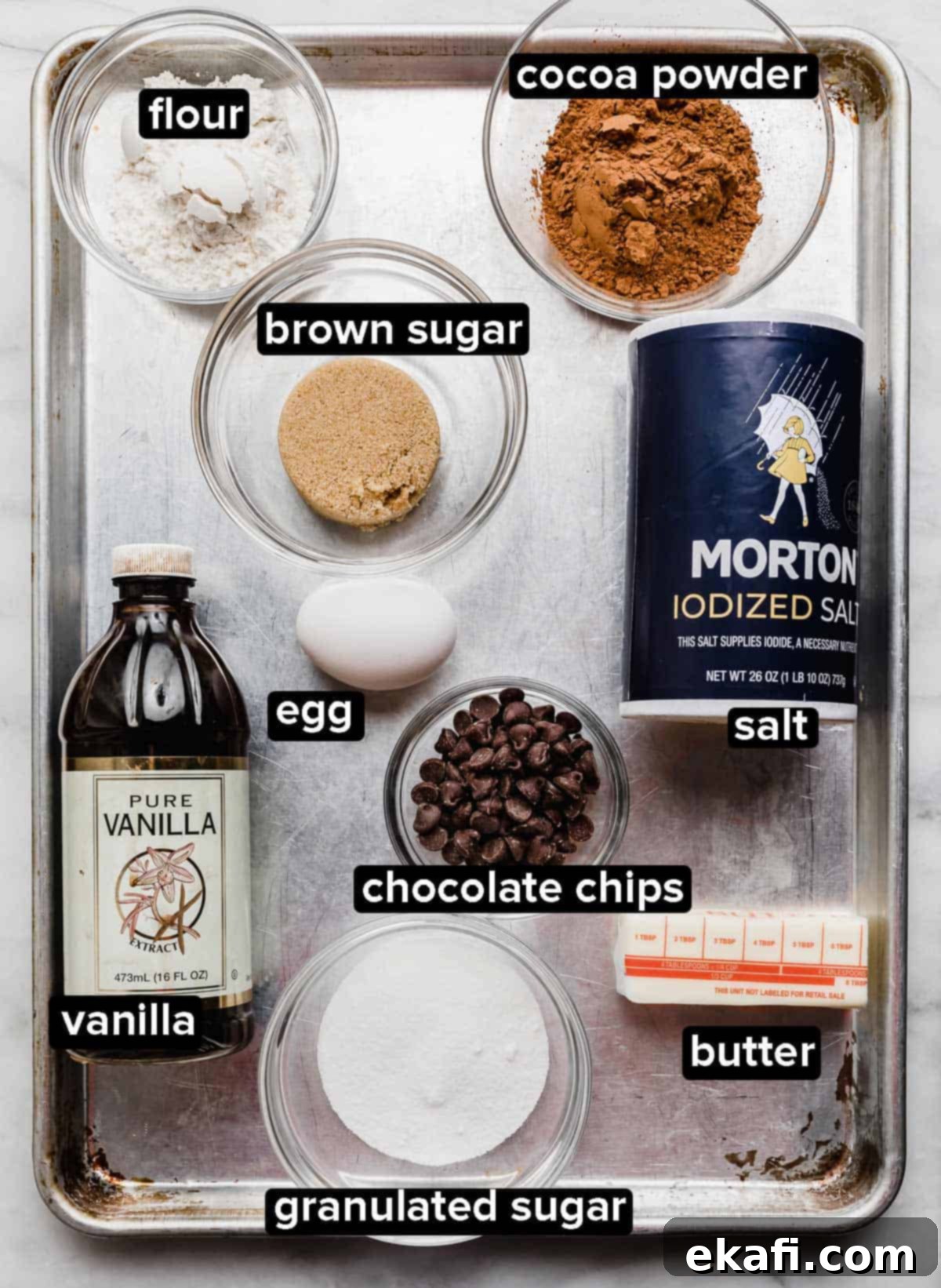 Brownies for Two 3 All the simple ingredients for small batch brownies, portioned into glass bowls on a baking sheet, ready for mixing.