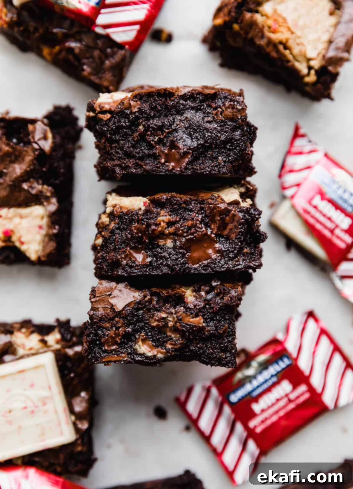 Μπράουνις με Κρουστά Σοκολάτας Μέντας 2 Peppermint Bark Brownies κομμένα σε τετράγωνα κομμάτια σε λευκό φόντο, έτοιμα για σερβίρισμα.