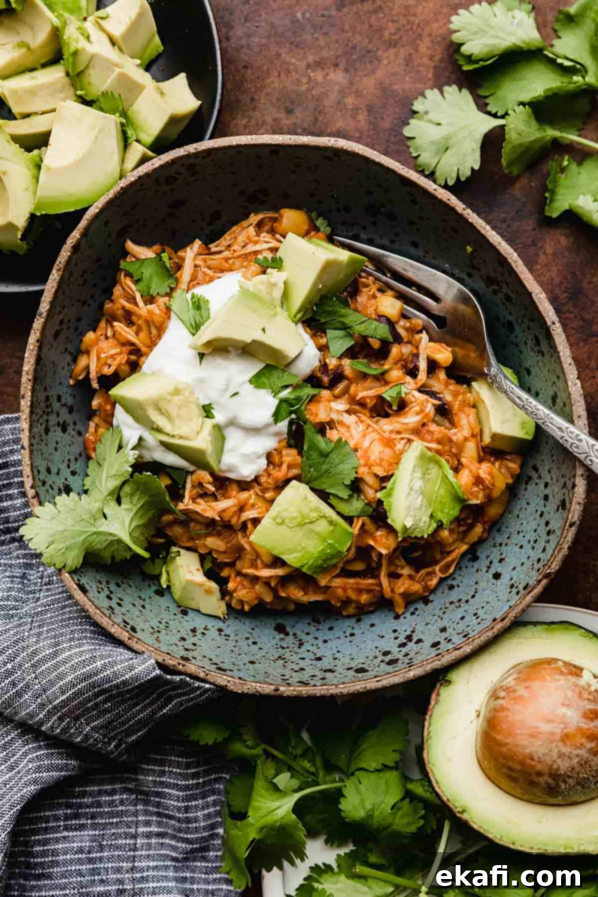 Γρήγορα Μπολ Κοτόπουλο Τάκο 2 Instant Pot Chicken Taco Bowls σε μπλε μπολ με κρέμα γάλακτος, κόλιανδρο και αβοκάντο.