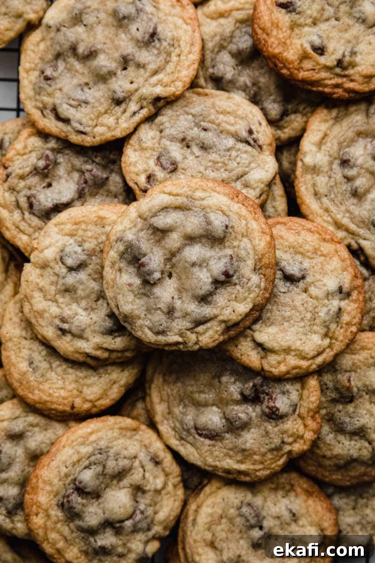Nestle Toll House Signature Chocolate Chip Cookies 5 A large, inviting pile of golden-brown Nestle Toll House Chocolate Chip Cookies, showcasing their classic appeal and delicious texture.