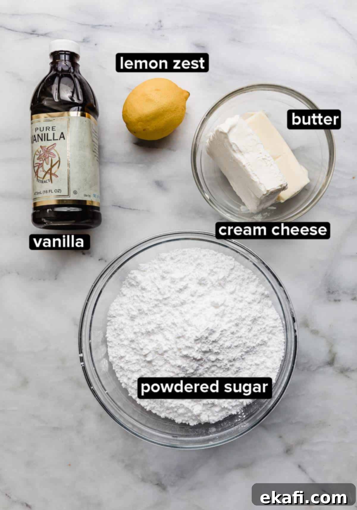 Fruity Dessert Cookie Pizzas 4 Key frosting ingredients including powdered sugar, softened butter, cream cheese, fresh lemon, and vanilla extract, arranged on a pristine white marble surface.