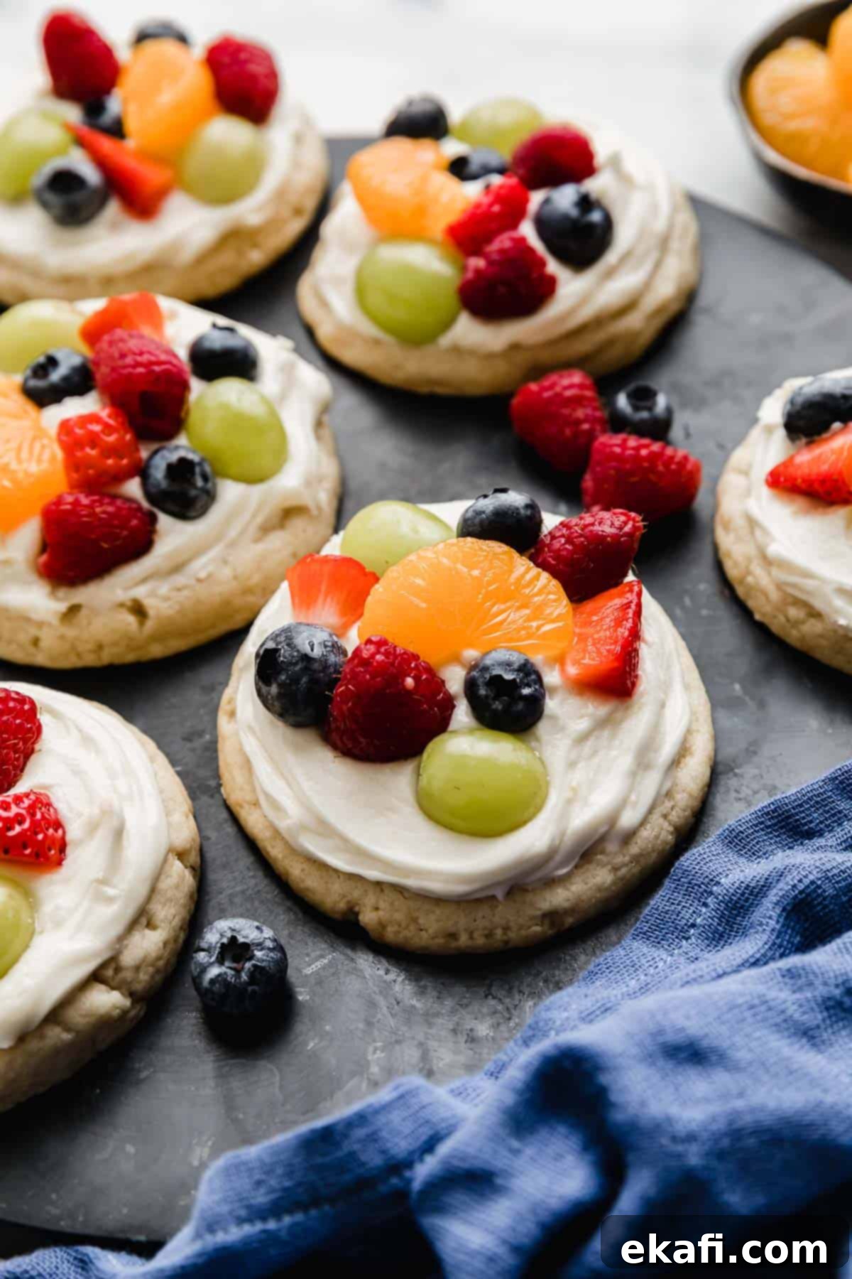 Fruity Dessert Cookie Pizzas 9 A perfectly arranged plate of Crumbl Fruit Pizza Cookies on a sleek black serving plate, ready to be enjoyed.