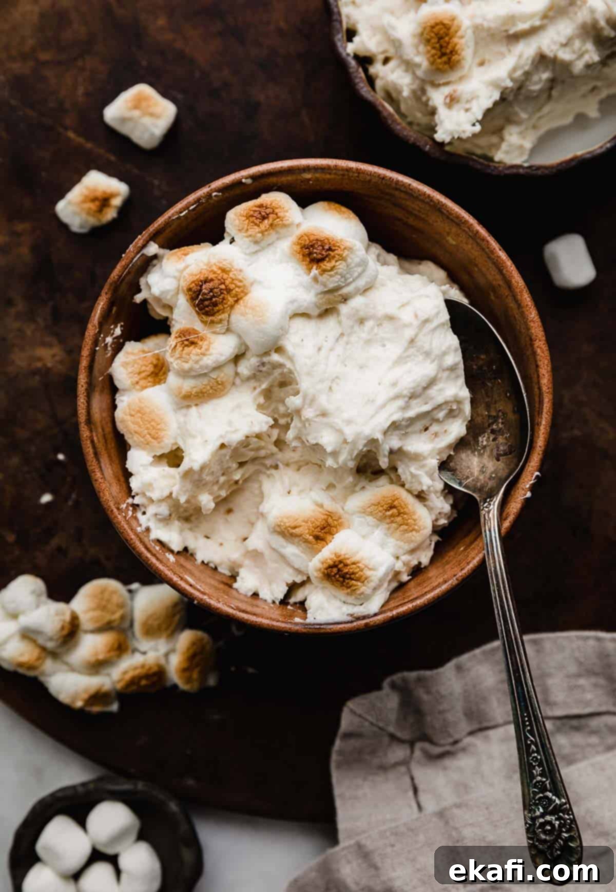 Καβουρδισμένο Μαρσμάλοου Γλάσο 2 Toasted Marshmallow Frosting made with real toasted marshmallows, in a brown bowl on a dark brown surface.