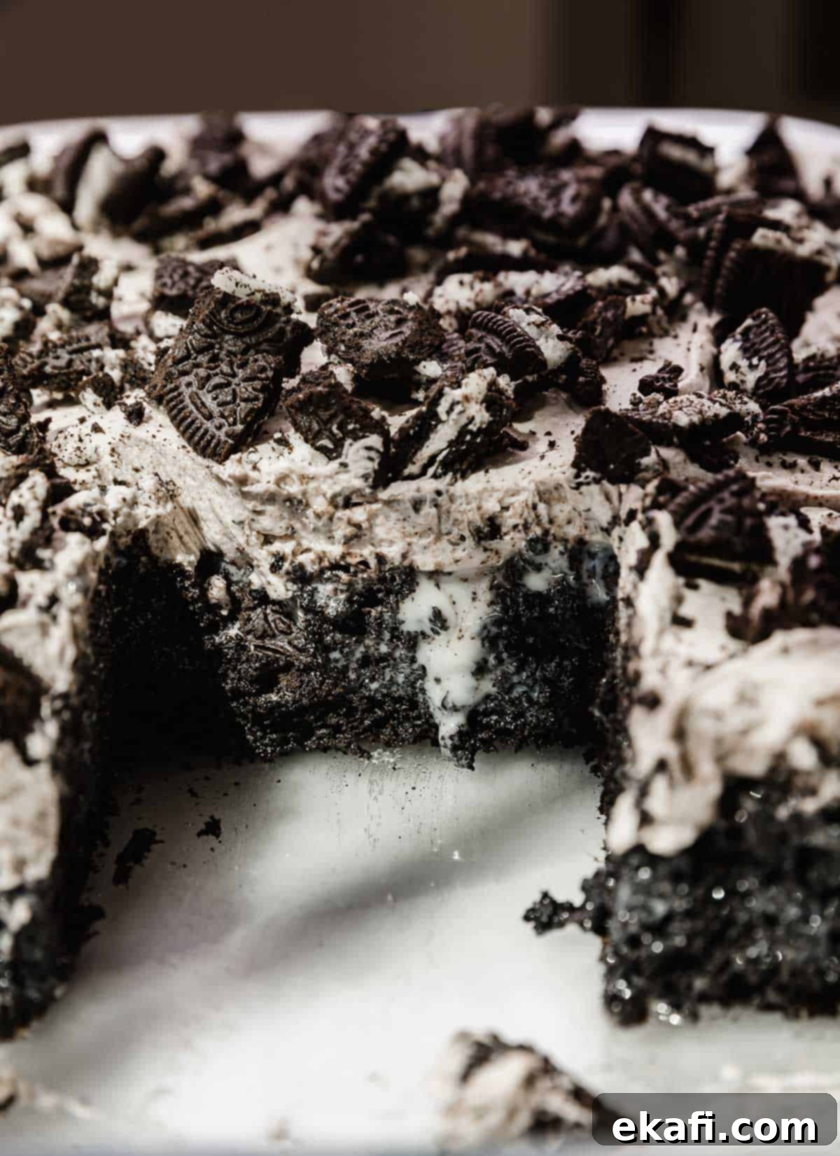 Όρεο Τρυπητό Κέικ 9 Ένα Oreo Poke Cake που ξεχειλίζει από γλυκό συμπυκνωμένο γάλα, και με επικάλυψη από παγωτό Oreo και θρυμματισμένα Oreo.