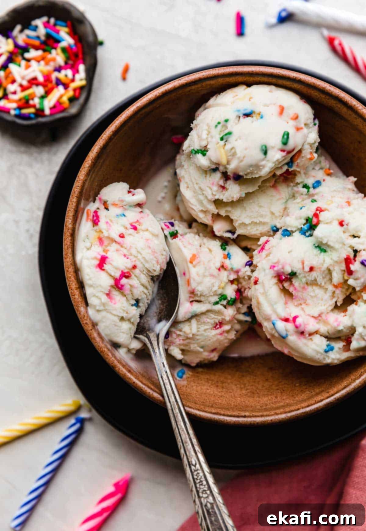 Confetti Cake Ice Cream 2 Three scoops of Birthday Cake Ice Cream with sprinkles, in a brown bowl.