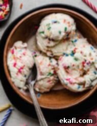 Confetti Cake Ice Cream 8 Three scoops of Birthday Cake Ice Cream with sprinkles, in a brown bowl.