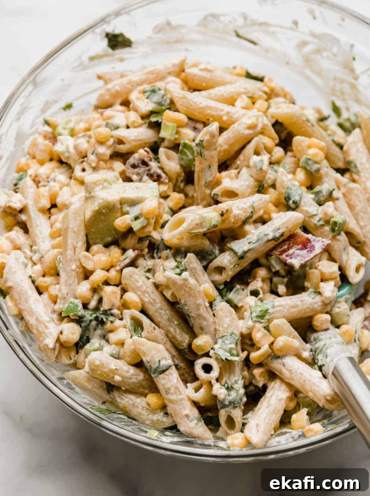 Elote Fiesta Pasta Salad 6 Mexican Street Corn Pasta Salad with corn, cilantro, and a mayo and sour cream dressing mixed into the bowl.