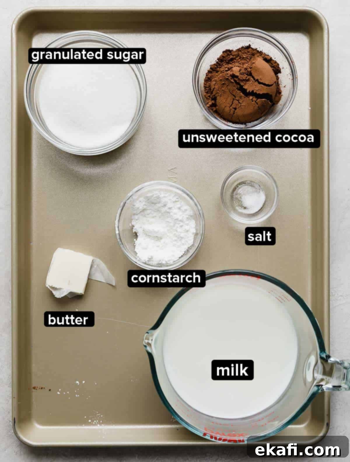 Chocolate Poke Cake 4 Ingredients for homemade chocolate pudding, including milk, granulated sugar, cornstarch, cocoa powder, and chopped semi-sweet chocolate, ready for preparation on a white surface.