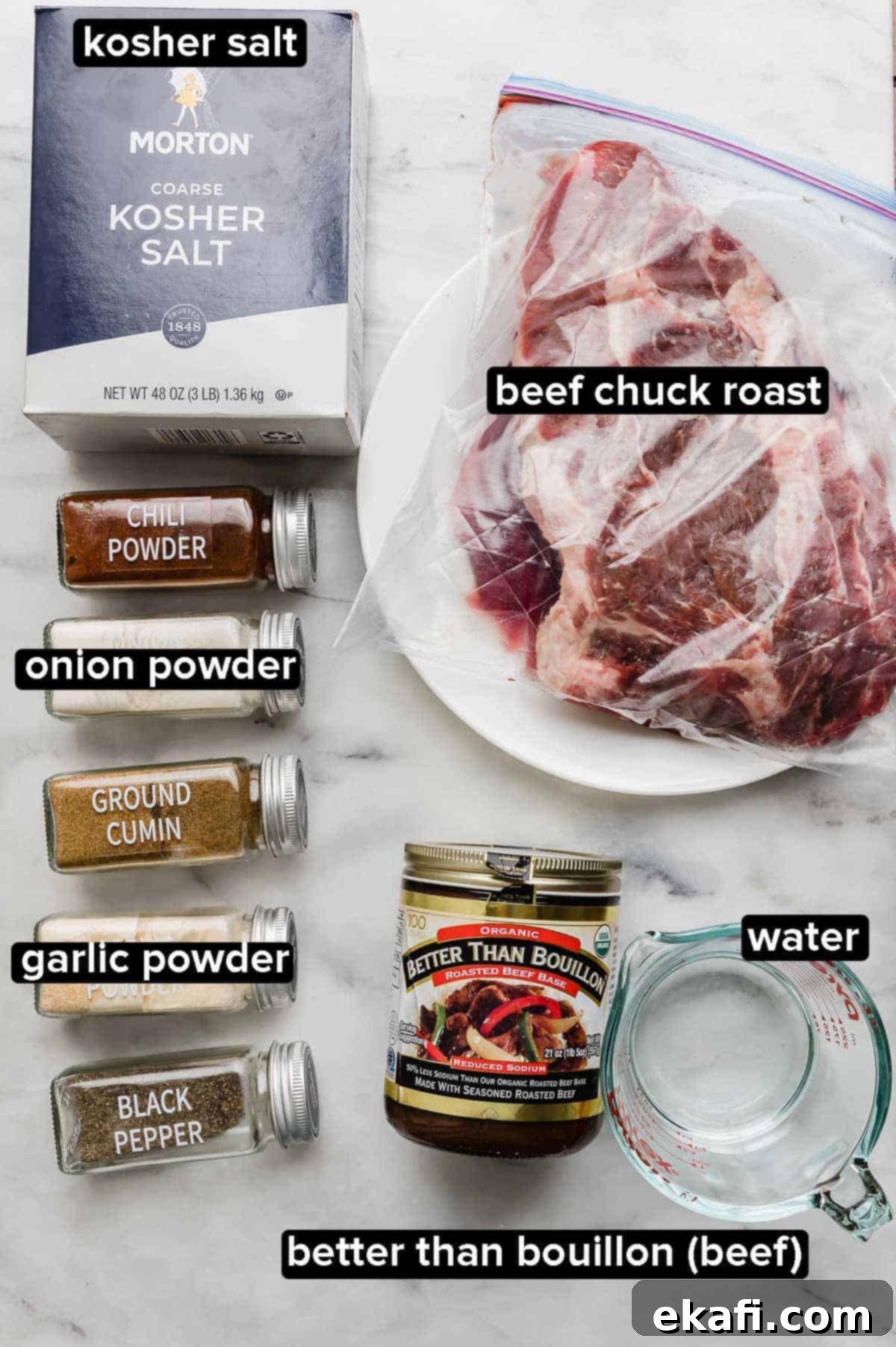 Fall-Apart Tender Slow Cooker Beef Tacos 3 Crock Pot Shredded Beef Tacos ingredients on a marble surface: beef chuck roast, kosher salt, chili powder, onion and garlic powder, cumin, and black pepper, with water and beef bouillon.